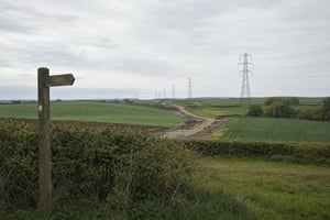 Rolling UK farmland with a line of electricity pylons