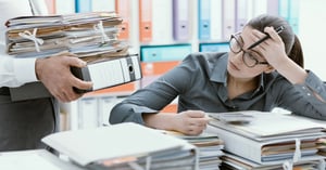 working woman looking at a pile of folders